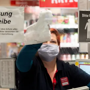 Manche Beschäftigte im Einzelhandel tragen Maske – andere nicht. Woran liegt das? (Symbolbild Kassiererin mit Maske)