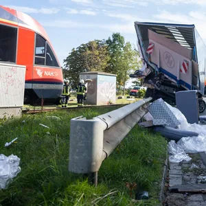 Ein zerstörter Lkw und ein zerstörtes Auto sind zu sehen, daneben der Zug
