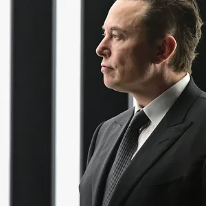 Musk steht vor einer weiß-schwarzen Wand