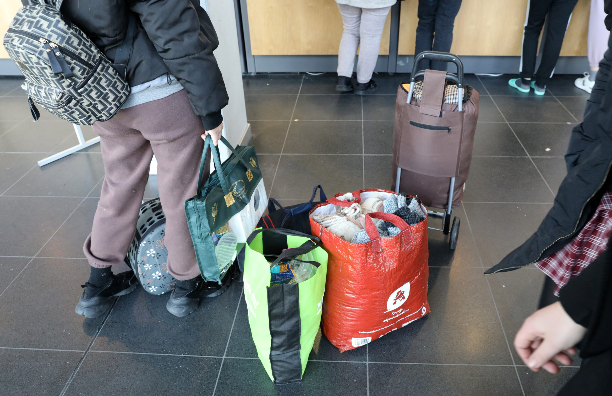 In der Hansemesse melden sich ankommende Flüchtlinge aus der Ukraine bei der Information, ihr Gepäck steht dabei auf dem Boden.