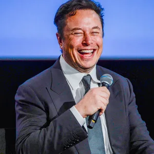 Musk spricht auf einer Bühne in ein Mikrofon