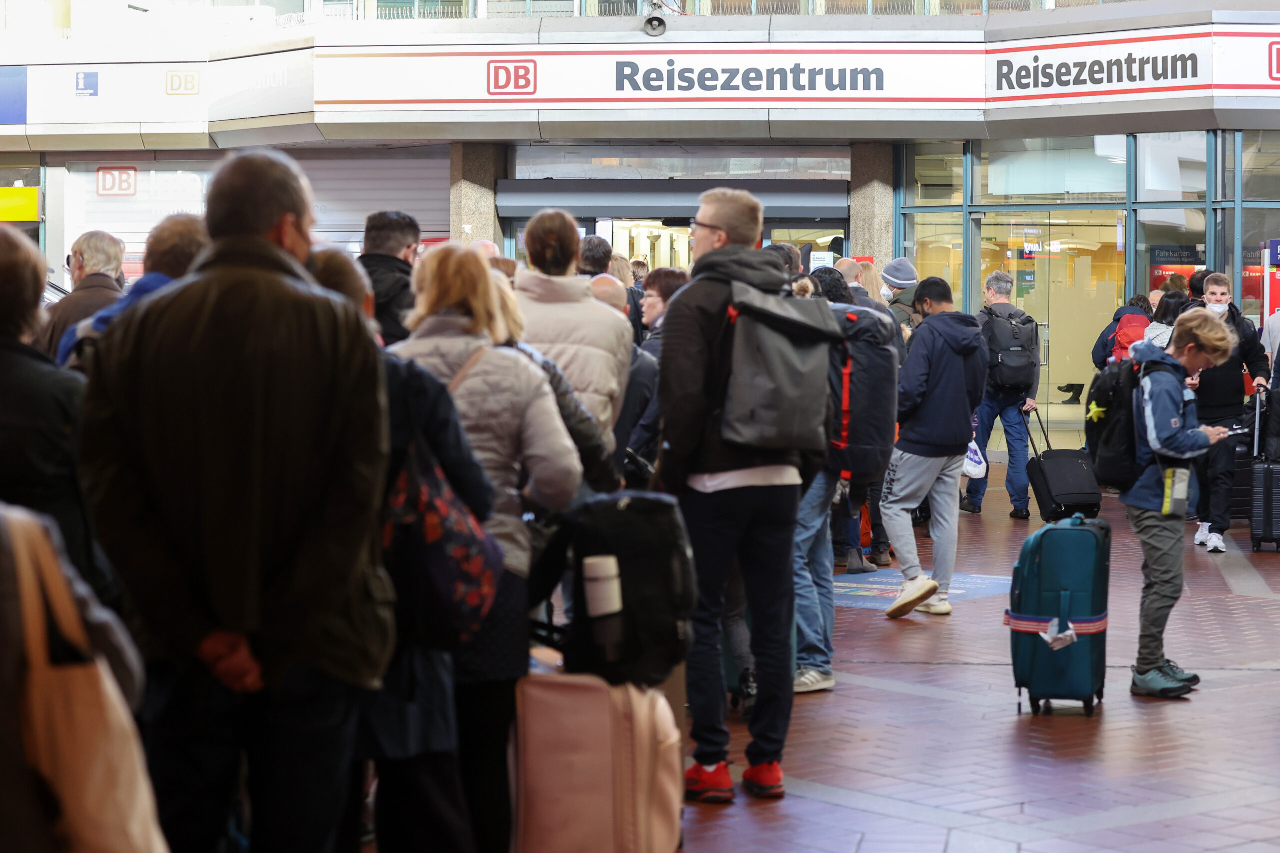 Reisende stehen in langen Schlangen im Hauptbahnhof Hamburg am Reisezentrum an