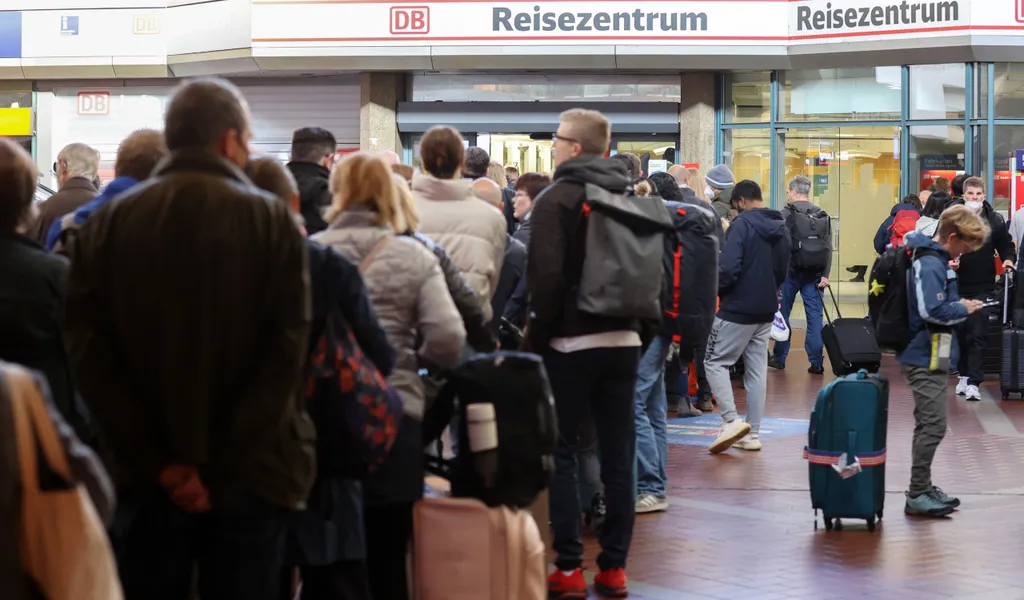 Reisende stehen in langen Schlangen im Hauptbahnhof Hamburg am Reisezentrum an