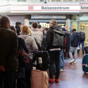 Reisende stehen in langen Schlangen im Hauptbahnhof Hamburg am Reisezentrum an