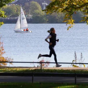 Eine Joggerin läuft am Ufer der Außenalster.