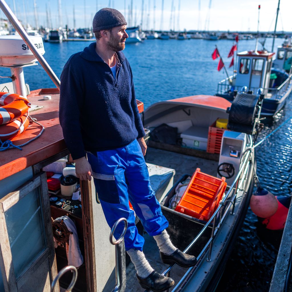 Ostseefischer Hendrik Kern steht auf seinem Fischkutter TAR18 im kleinen Fischerhafen in Tarnewitz an der Ostsee.