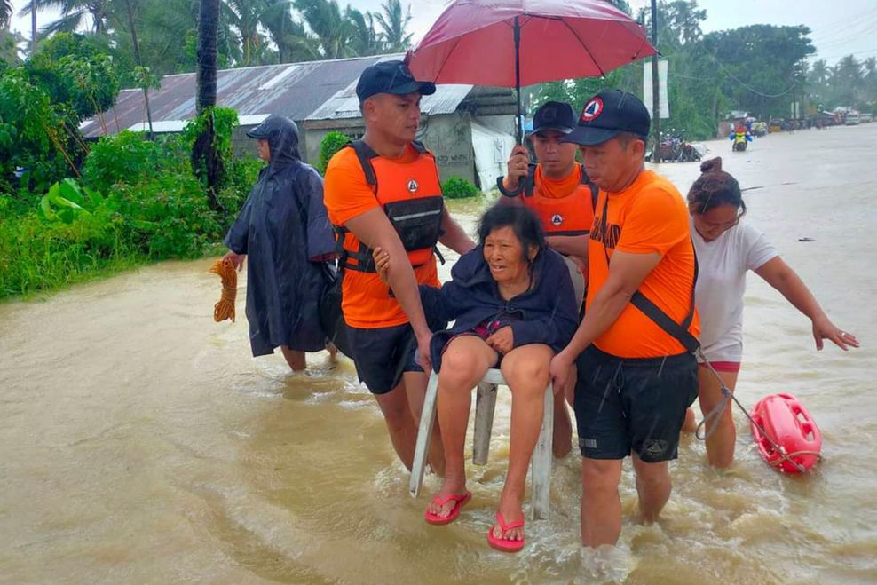 Philippinen: Rettungskräfte evakuieren eine Seniorin, deren Haus überschwemmt wurde.