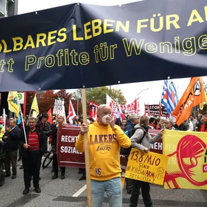 Demonstrationsteilnehmer halten ein Transparent auf einer Demonstration unter dem Motto „Solidarisch aus der Krise – bezahlbares Leben für alle statt Profite für wenige.“
