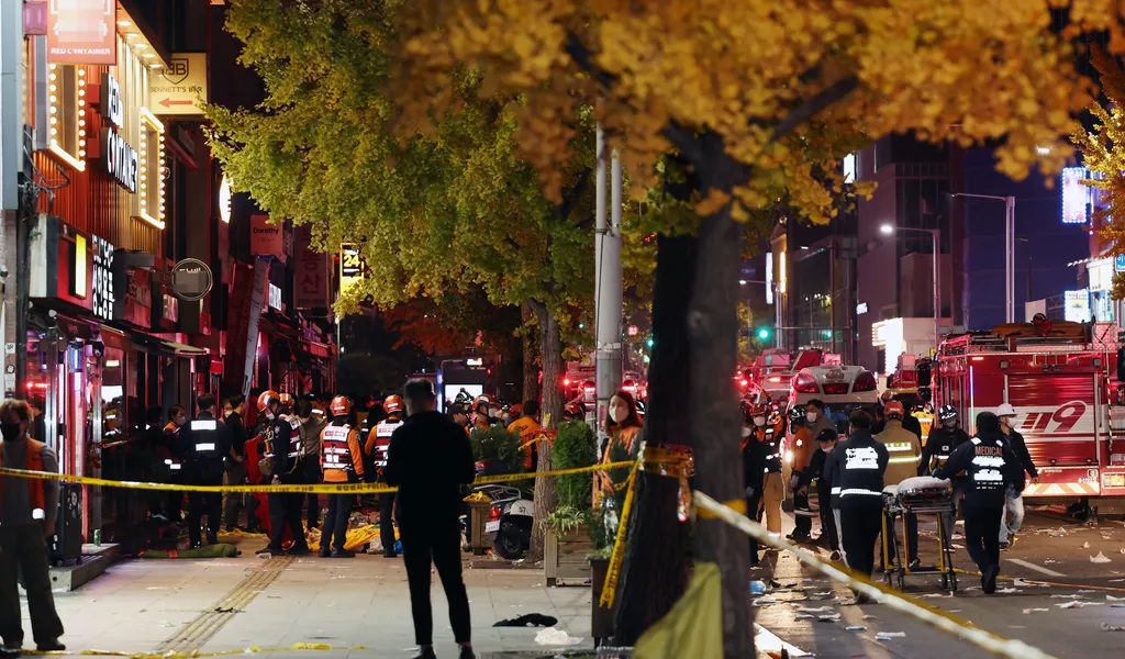 Rettungskräfte und Feuerwehrleute sind an der Unfallstelle im Einsatz. Dutzende Personen haben beim Ansturm auf Halloween-Feierlichkeiten in Seoul einen Herzstillstand erlitten.