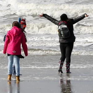 Spaziergänger gehen bei stürmischem Herbstwetter über den Strand von St. Peter-Ording. (Symbolbild)