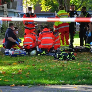 Rettungskräfte stehen auf einer Wiese um eine verletzte Person
