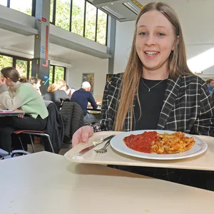 Studentin mit Mensa-Essen zum halben Preis.