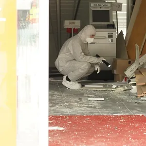 Ein Kripo-Ermittler untersucht den Tatort, eine Sparkassenfiliale in Kiel.