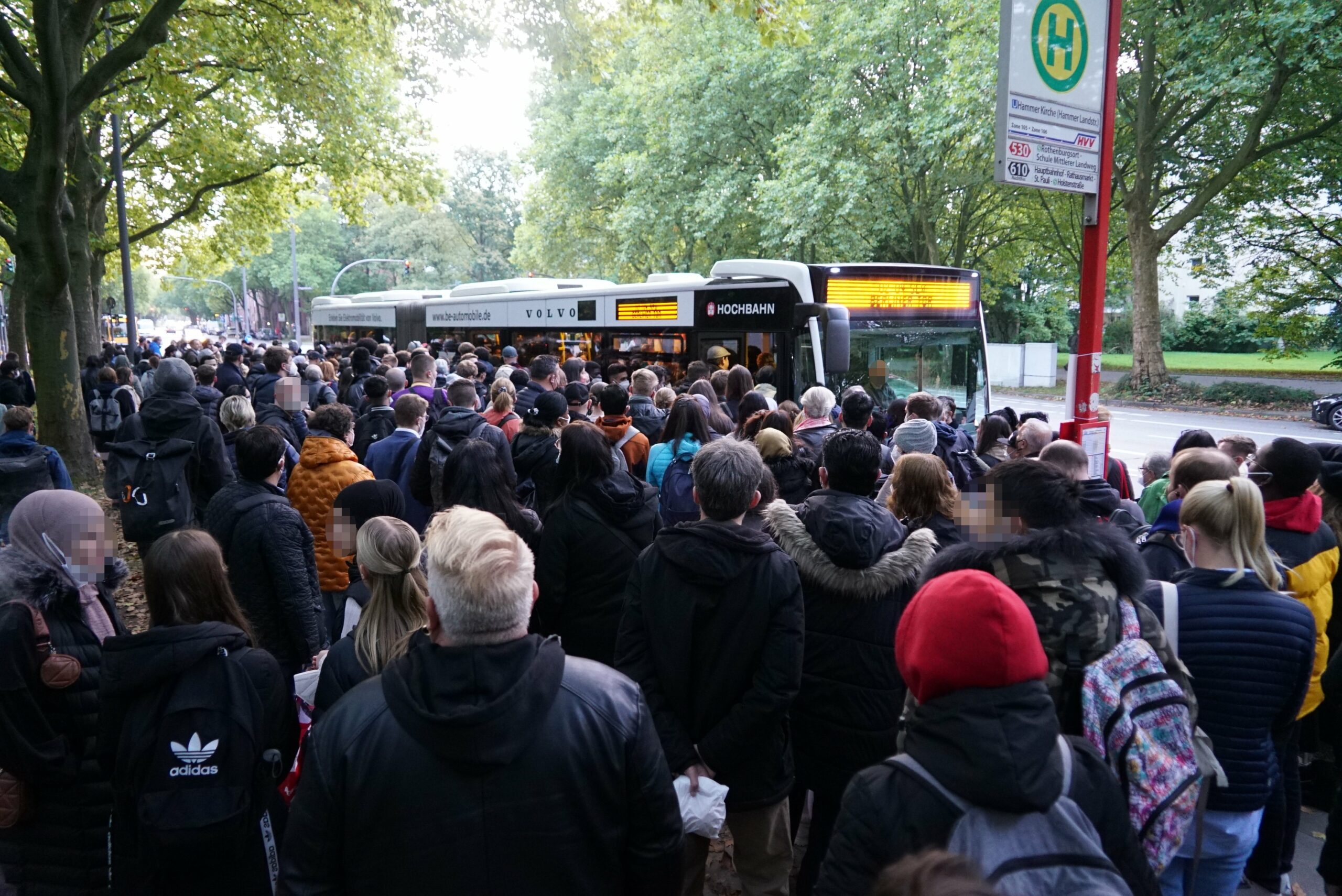 Zahlreiche Menschen drängen sich um einen Bus