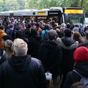Zahlreiche Menschen drängen sich um einen Bus