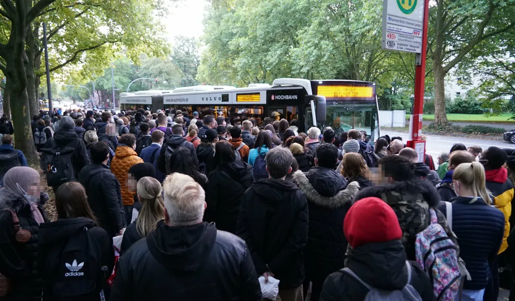 Zahlreiche Menschen drängen sich um einen Bus