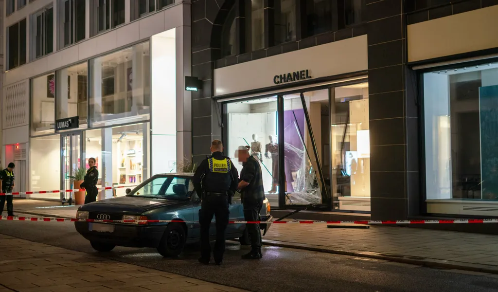 Ein Audi 80 steht vor dem zerstörten Schaufenster von Chanel am Neuen Wall