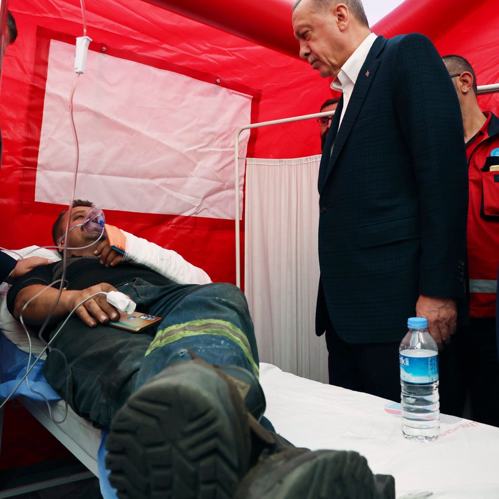 Der türkische Präsident Recep Tayyip Erdogan spricht mit einem verletzten Arbeiter.