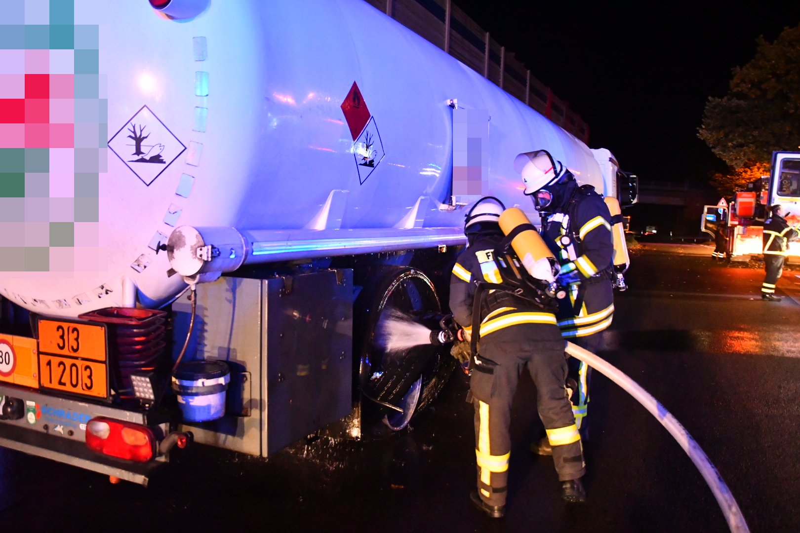 Feuerwehrmänner löschen den brennenden Reifen des Tankwagens.