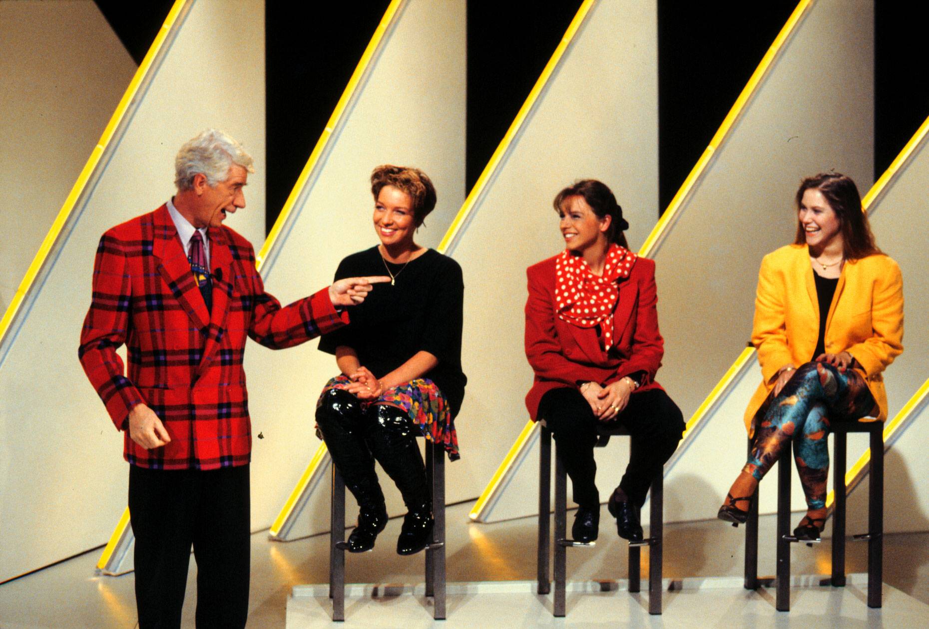 Rudi Carrell steht neben drei sitzenden Kandidatinnen in der ARD-Show „Herzblatt“