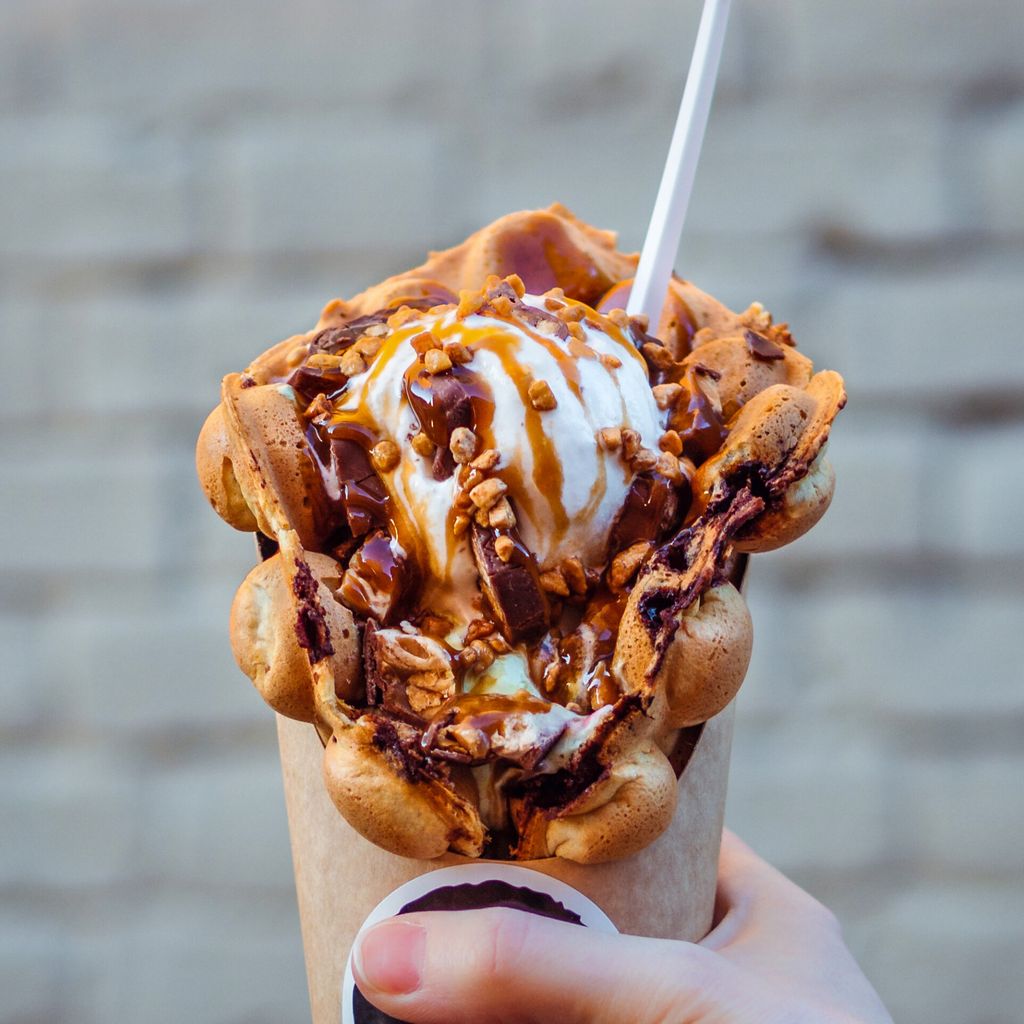 Eine Bubble-Waffel, gefüllt mit Eis und Soße: Die hubbelige Form macht sie besonders fluffig.