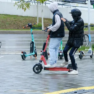 Zwei Jugendliche fahren auf einem E-Scooter.