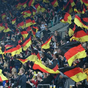 Fans der Deutschen Nationalmannschaft schwenken Fahnen.
