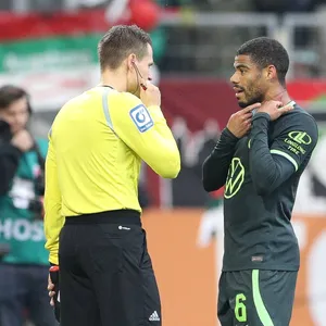Wolfsburg-Spieler Paulo Octavio zeigt dem Schiedsrichterassistenten die Kratzspuren am Hals.