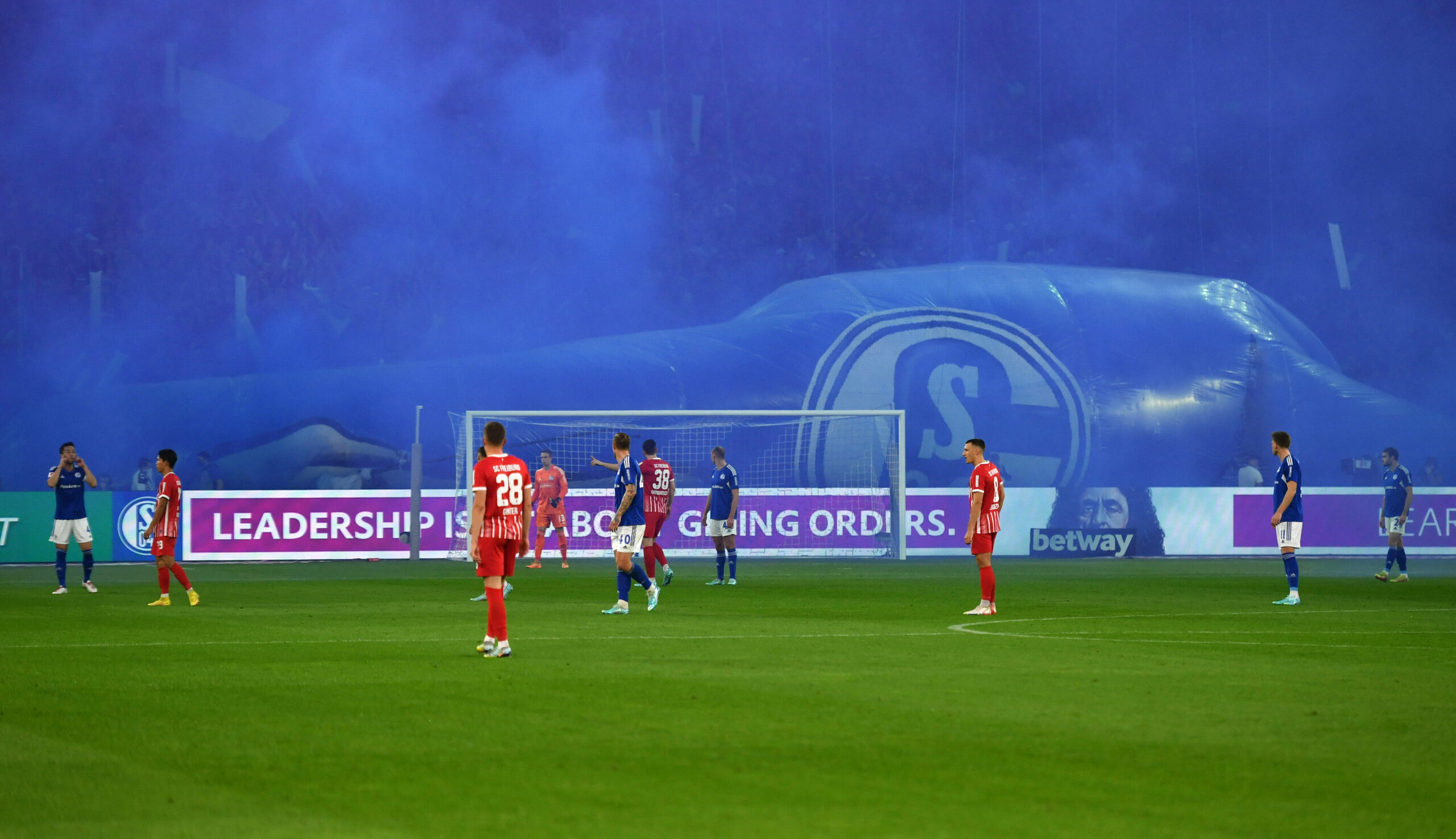 Blauer Rauch steht im Anschluss der Schalker Choreo über dem Spielfeld