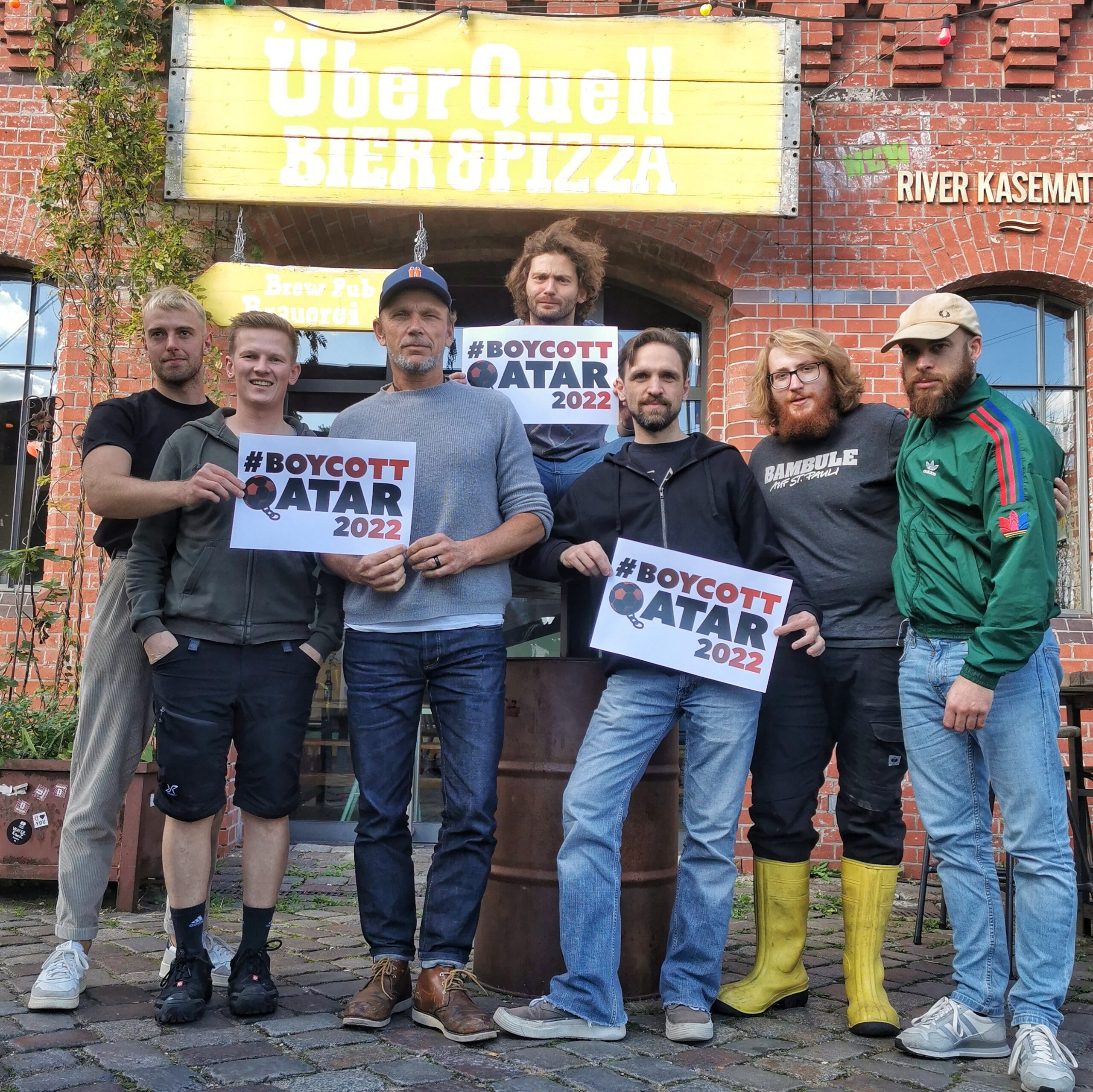 Das Team des „ÜberQuells“ mit Schildern, auf denen „Boykott“ steht.