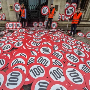 Klima-Aktivisten „schenken“ dem Verkehrsminister Tempo-100-Schilder.