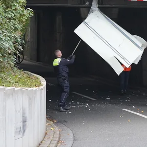 Ein Polizist löst ein feststeckendes Teile des Lasters aus der Unterführungsbrücke.