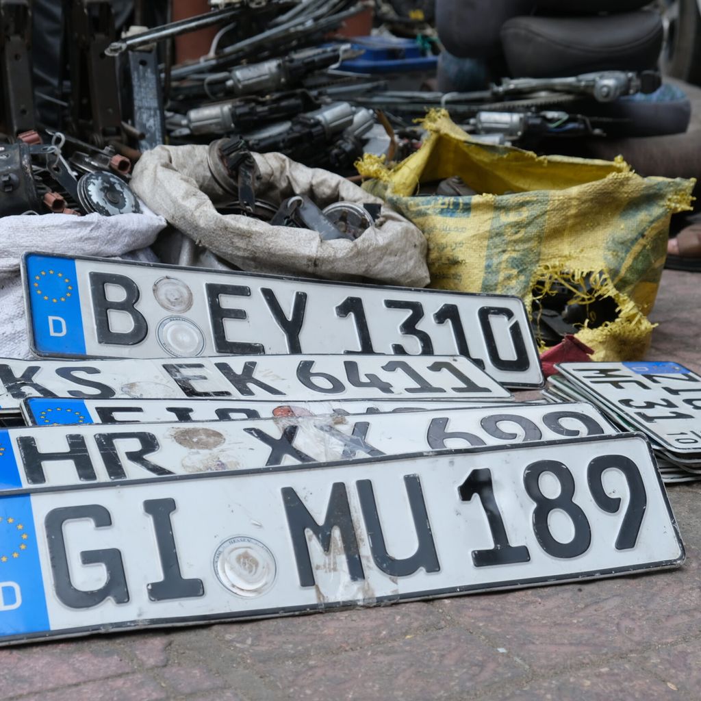 Alte deutsche Kennzeichen, an denen das Siegel für die deutsche Zulassung entfernt wurde, liegen auf dem Boden in einem Markt für Autoteile in Kairo.