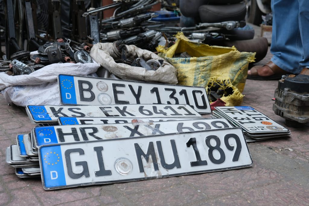 Alte deutsche Kennzeichen, an denen das Siegel für die deutsche Zulassung entfernt wurde, liegen auf dem Boden in einem Markt für Autoteile in Kairo.