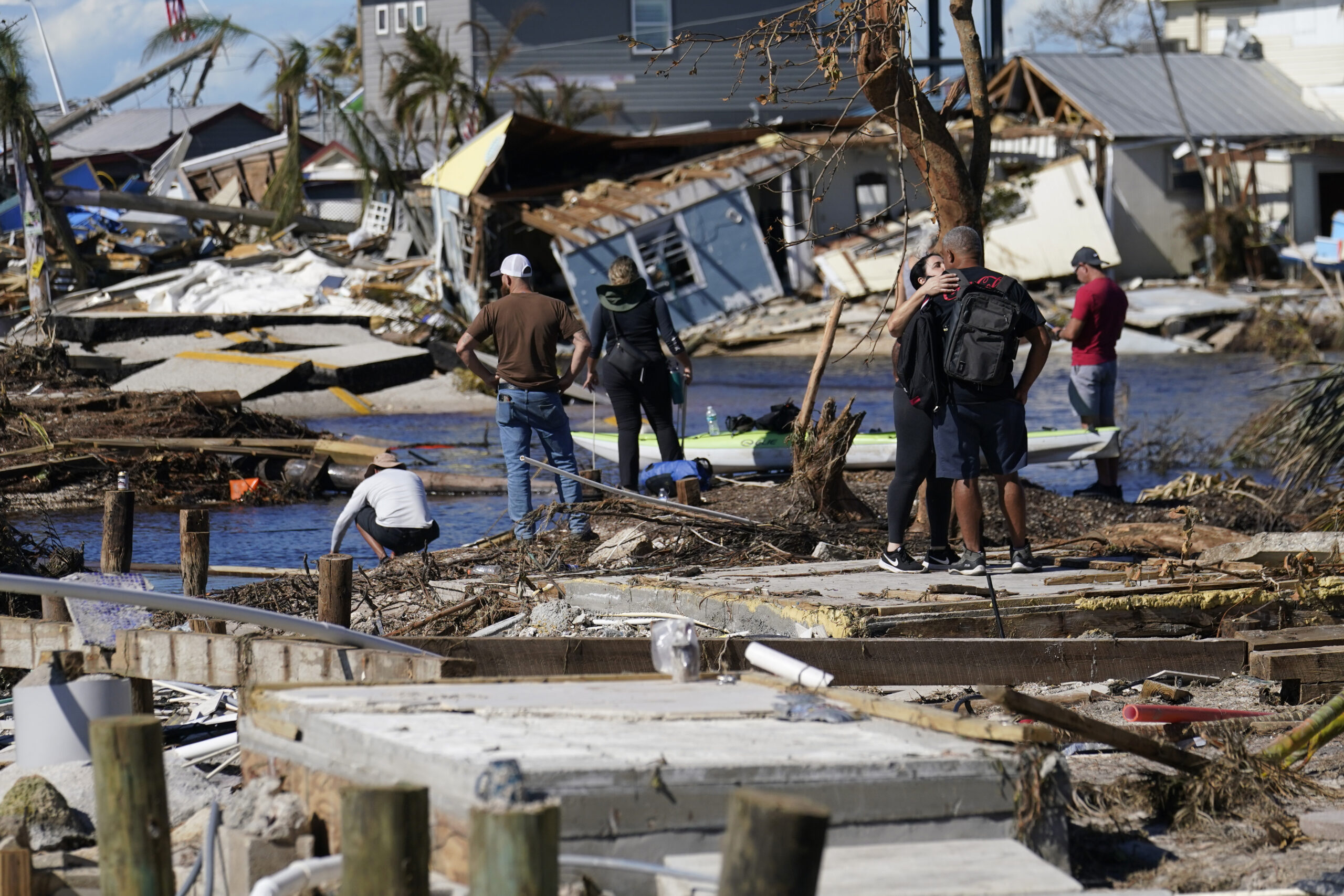 Menschen stehen auf der zerstörten Brücke nach Pine Island und betrachten die Schäden nach dem Hurrikan.