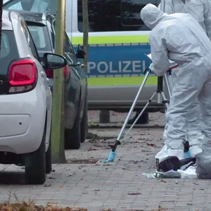 Ermittler sichern Spuren auf einem Bürgersteig in Heide, wo eine Frau erschossen wurde