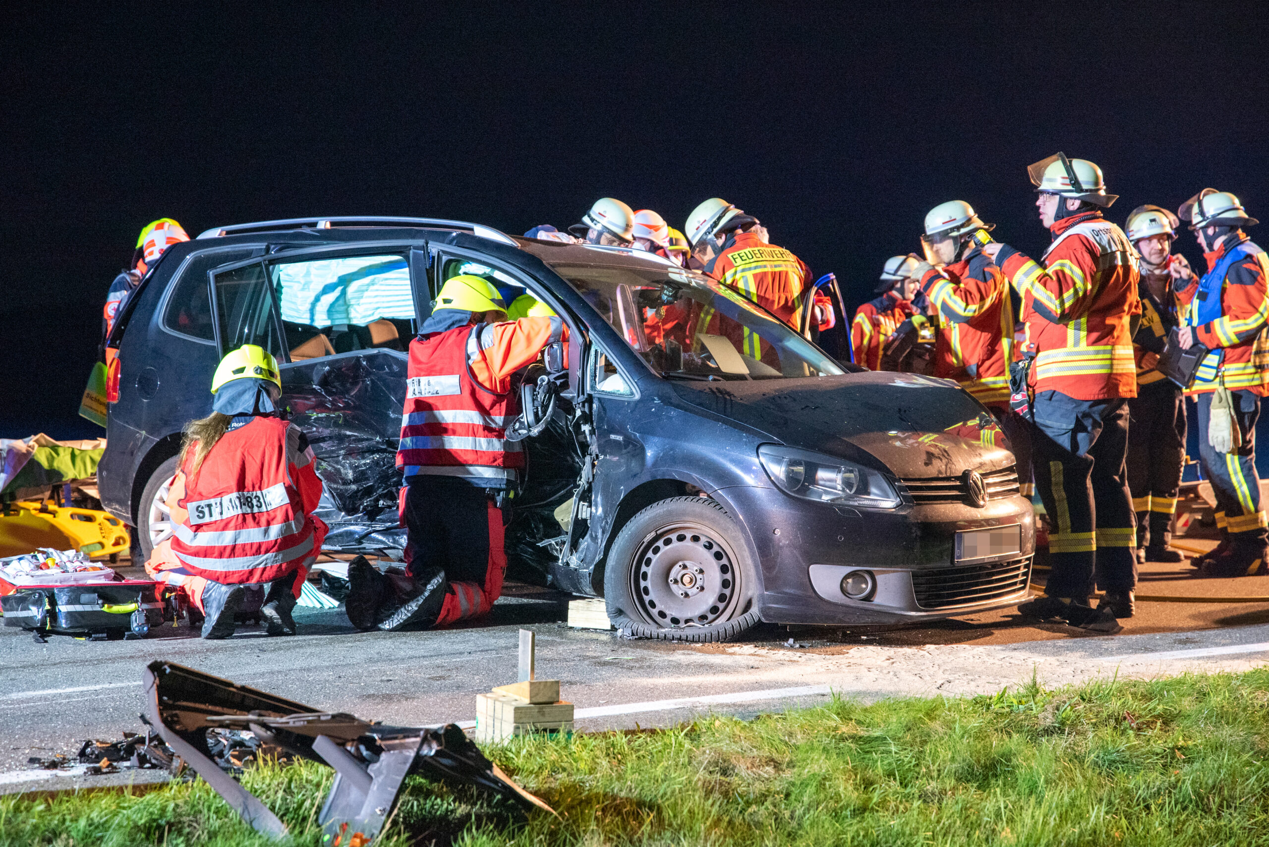 Feuerwehrkräfte retten Fahrer und Beifahrerin aus dem Touran; sie waren in dem Wrack eingeklemmt.