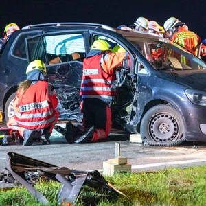 Feuerwehrkräfte retten Fahrer und Beifahrerin aus dem Touran; sie waren in dem Wrack eingeklemmt.