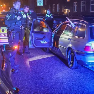 Polizisten filzen den BMW und kontrollieren die Insassen.