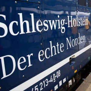 Regionalzug mit Schleswig-Holstein-Aufdruck am Bahnhof