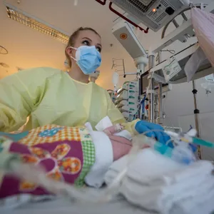 Eine Intensivpflegerin versorgt einen am Respiratorischen Synzytial-Virus (RSV) erkrankten Patienten, der beatmet wird.