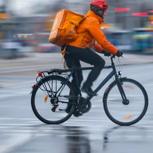 Ein Lieferando-Bote fährt auf einem Fahrrad