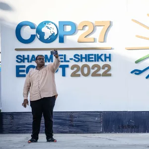 Ein Mann macht ein Selfie mit dem Logo der UN-Klimakonferenz COP27 im International Convention Center.