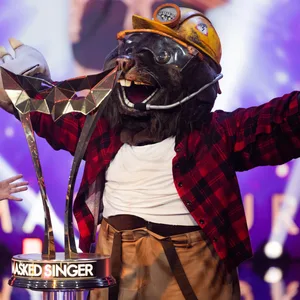 Der Maulwurf reißt die Arme neben dem Pokal hoch im Finale von „The Masked Singer“.