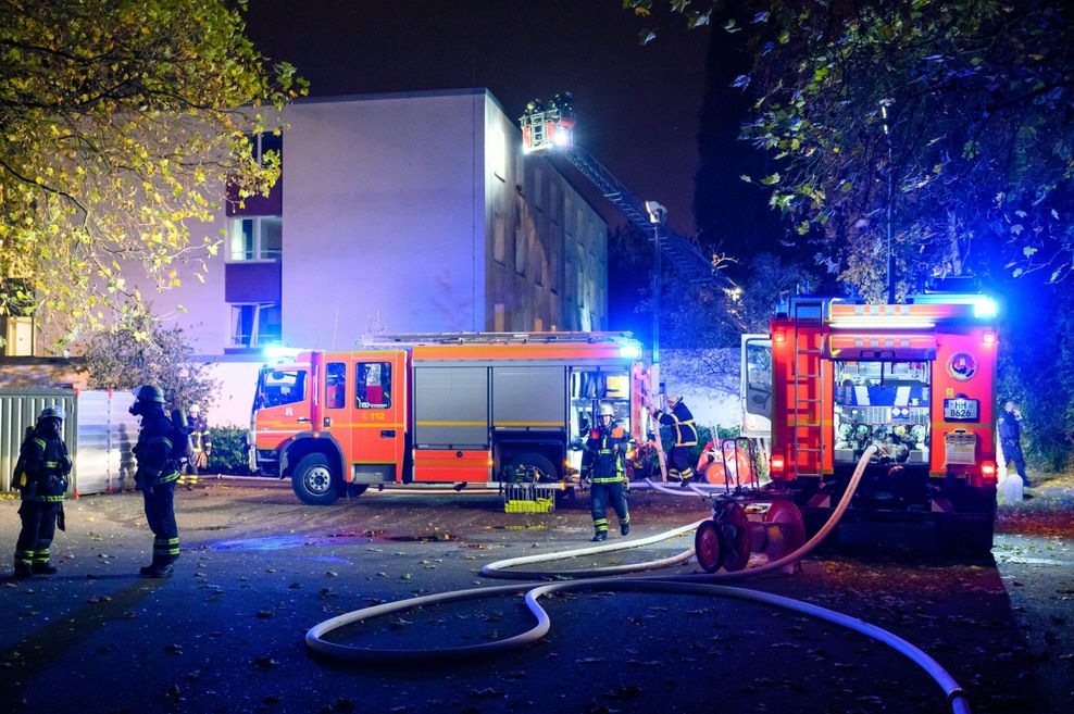 Löschfahrzeuge und eine Drehleiter der Feuerwehr vor dem beschädigten Gebäude in Stellingen, wo es eine Explosion gab