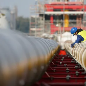 Arbeiter bauen Gas-Pipelines für den geplanten LNG-Flüssiggas-Schwimmterminal zusammen.