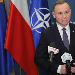 Präsident Duda vor den Flaggen von der EU, Polen und der NATO