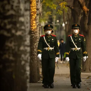 Chinesische paramilitärische Polizisten mit medizinischen Masken gehen in Formation eine Straße in Peking entlang.
