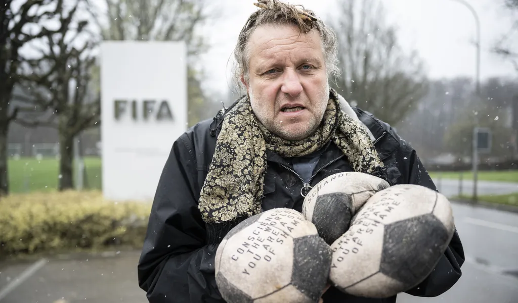 Volker-Johannes Trieb bei seiner Protestaktion am Tag der WM-Auslosung. Er hält einige der genähten Bälle in der Hand