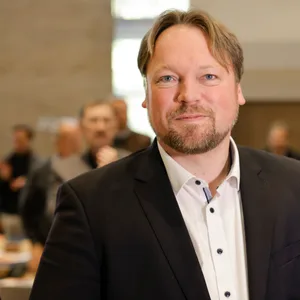 Der neue schleswig-holsteinische FDP-Vorsitzende Oliver Kumbartzky lächelt, während Delegierte zu seinem Sieg applaudieren